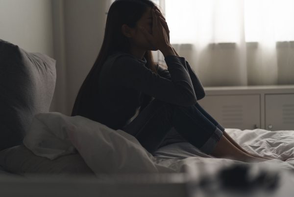 girl with head in hands on bed